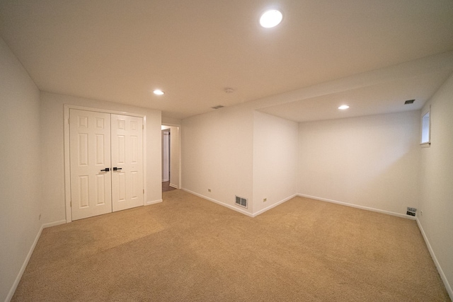 finished below grade area featuring light colored carpet, visible vents, and recessed lighting