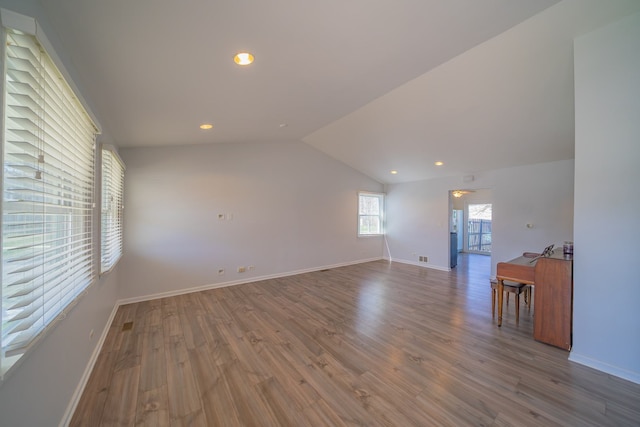 unfurnished living room with recessed lighting, vaulted ceiling, baseboards, and wood finished floors