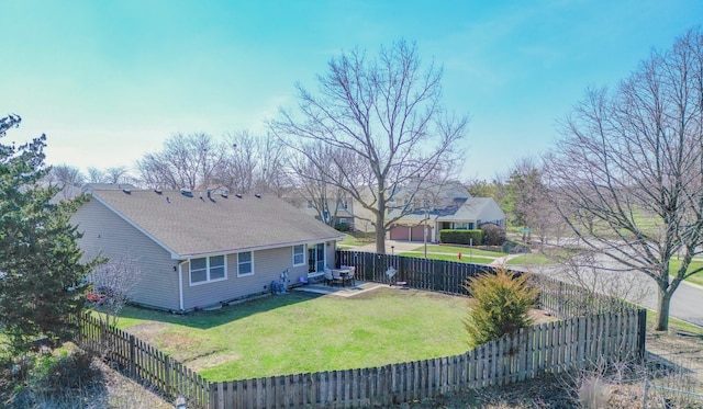 exterior space featuring a fenced backyard, roof with shingles, a yard, and a patio