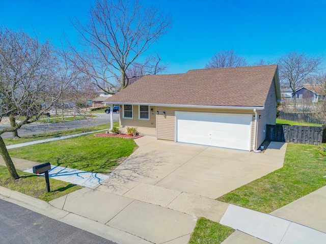 ranch-style home featuring fence, a shingled roof, concrete driveway, an attached garage, and a front yard