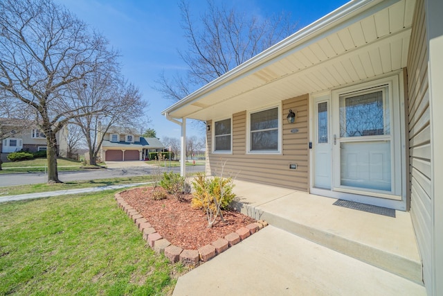 entrance to property featuring a porch and a yard