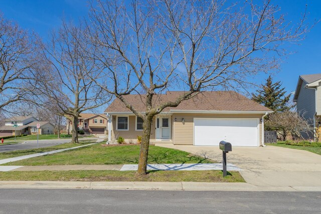view of front facade with concrete driveway, an attached garage, and a front lawn