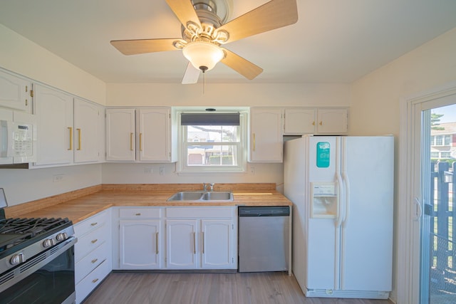 kitchen featuring white cabinets, light countertops, appliances with stainless steel finishes, and a sink