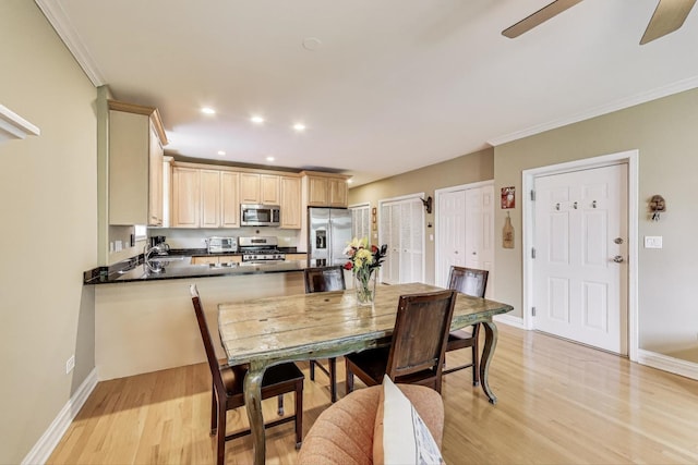 4860 N Kenmore Ave Unit 4S, Chicago, IL 60640 - kitchen featuring stainless steel appliances, light wood finished floors, a peninsula, dark countertops, and crown molding