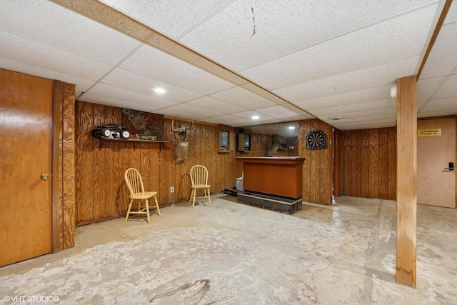 indoor dry bar with a drop ceiling and wooden walls