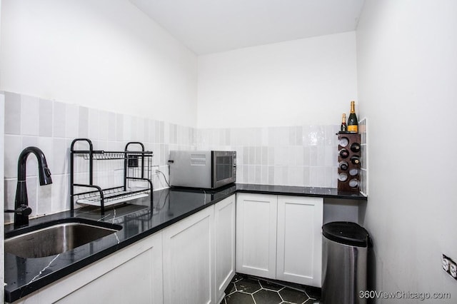 304 Polo Ln, Oak Brook, IL 60523 - kitchen featuring stainless steel microwave, a sink, tasteful backsplash, dark stone countertops, and white cabinetry