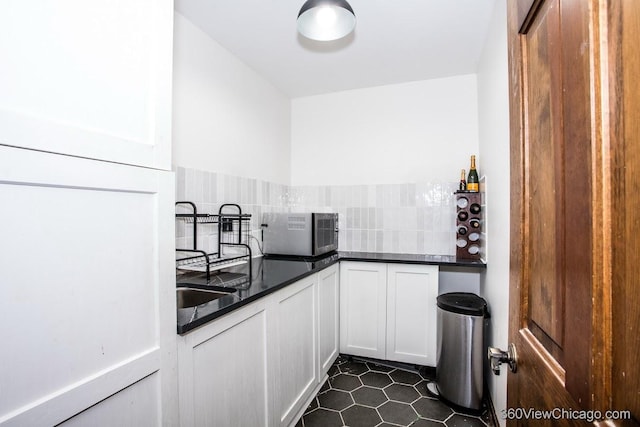 304 Polo Ln, Oak Brook, IL 60523 - kitchen with backsplash, dark countertops, white cabinets, and dark tile patterned flooring