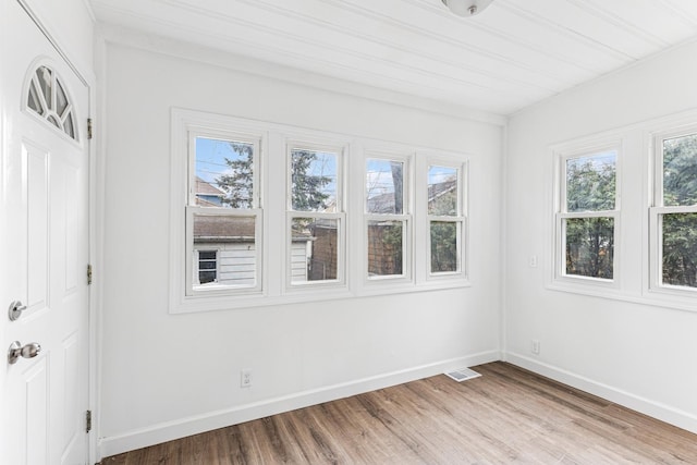 interior space with visible vents, baseboards, and wood finished floors