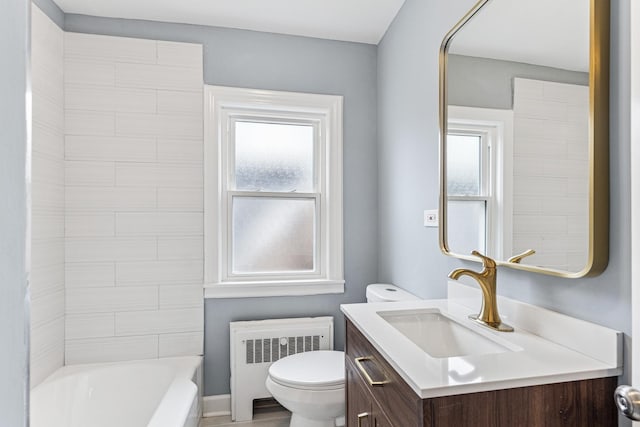 bathroom with toilet, vanity, plenty of natural light, and radiator
