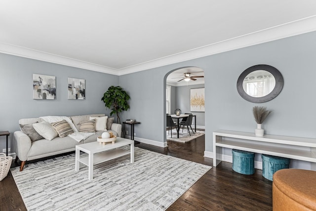 living room with crown molding, wood finished floors, baseboards, and a ceiling fan