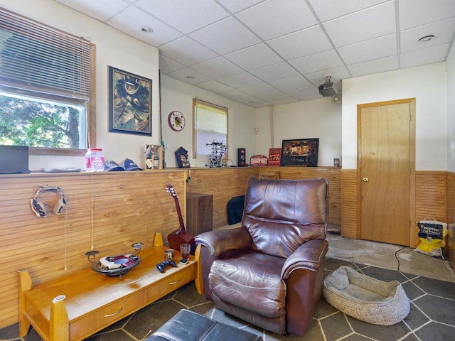 living area with a drop ceiling