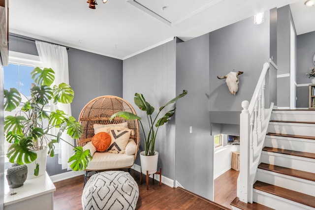 living area with ornamental molding, wood finished floors, and stairs
