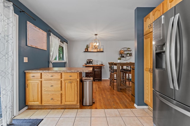 1407 Centennial Dr, Champaign, IL 61821 - kitchen featuring stainless steel fridge with ice dispenser, a chandelier, light tile patterned floors, hanging light fixtures, and a peninsula