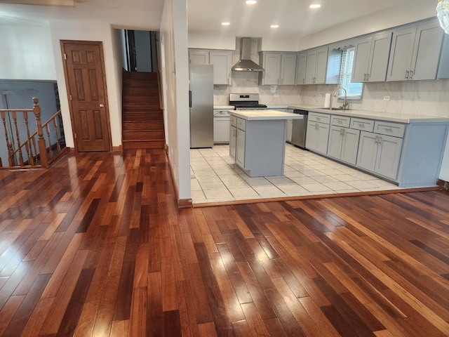 11723 S S Ave J, Chicago, IL 60617 - kitchen with wall chimney range hood, light wood-style flooring, gray cabinetry, appliances with stainless steel finishes, and a sink