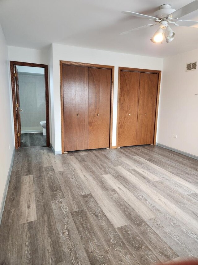 11723 S S Ave J, Chicago, IL 60617 - unfurnished bedroom with visible vents, baseboards, two closets, a ceiling fan, and wood finished floors