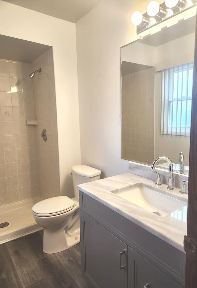 11723 S S Ave J, Chicago, IL 60617 - bathroom featuring tiled shower, vanity, toilet, and wood finished floors