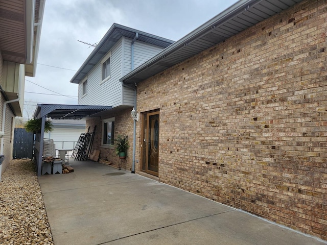 11723 S S Ave J, Chicago, IL 60617 - view of side of property with a patio area, fence, brick siding, a garage, and driveway