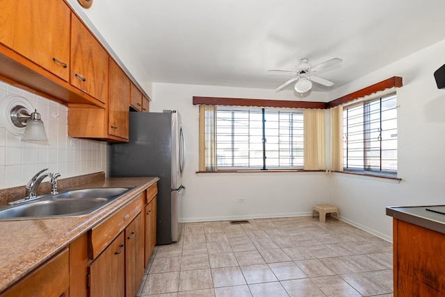 640 W 95th St, Chicago, IL 60628 - kitchen with tasteful backsplash, visible vents, a sink, a ceiling fan, and brown cabinets