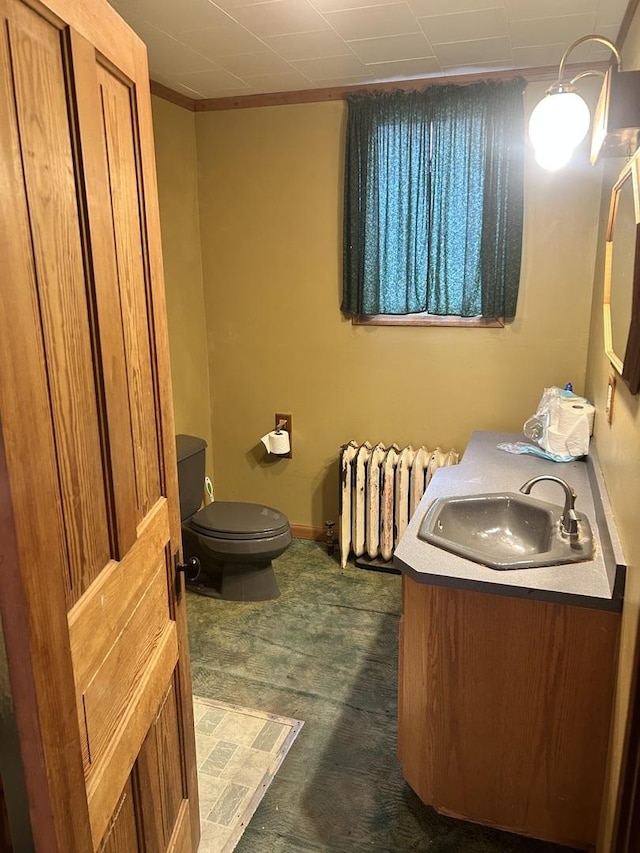 bathroom with radiator heating unit, toilet, and vanity