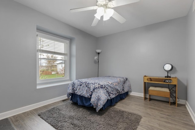 bedroom with baseboards, a ceiling fan, and wood finished floors