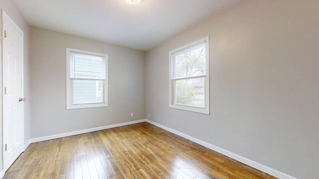 unfurnished room featuring baseboards and light wood-style flooring