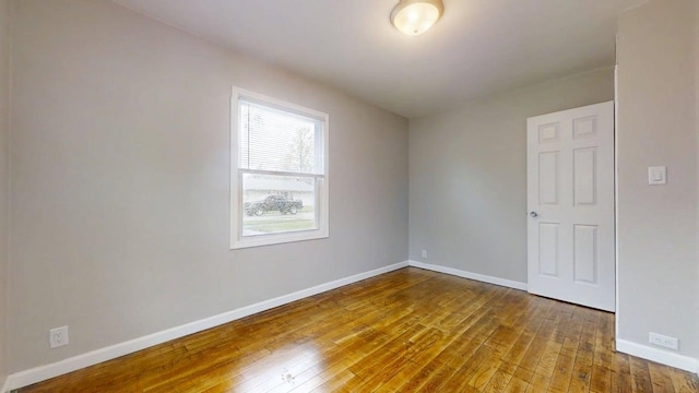 spare room featuring baseboards and hardwood / wood-style floors