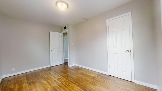 unfurnished bedroom with baseboards, light wood-style flooring, and visible vents