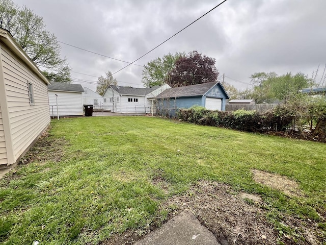view of yard featuring fence and a garage