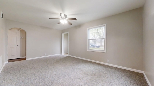 unfurnished room featuring arched walkways, ceiling fan, baseboards, and carpet flooring