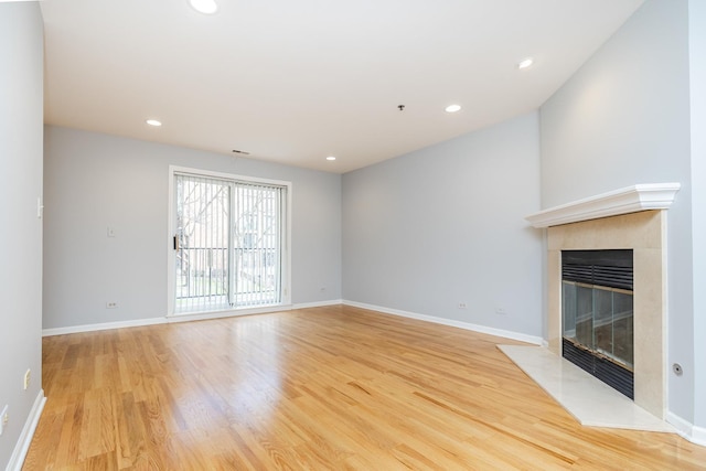 unfurnished living room featuring a fireplace, light wood-style floors, baseboards, and recessed lighting