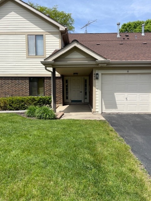 840 E Coach Rd Unit 5, Palatine, IL 60074 - view of front facade featuring an attached garage, a front lawn, brick siding, and asphalt driveway