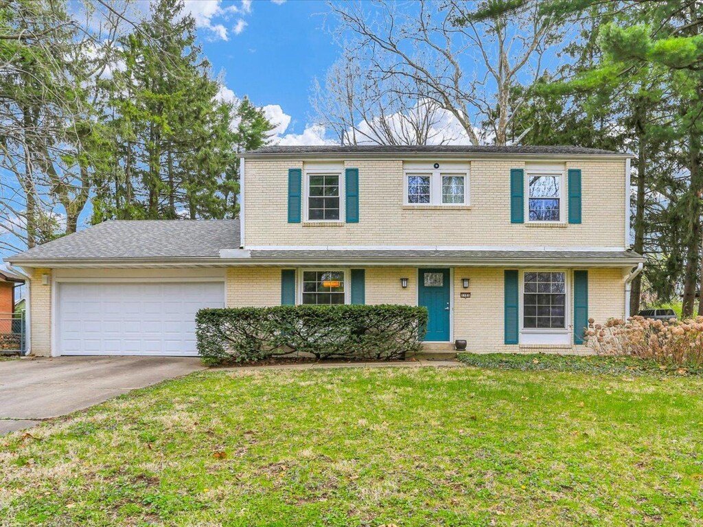 1101 Foothill Dr, Champaign, IL 61821 - traditional-style home with a garage, driveway, a front yard, and brick siding