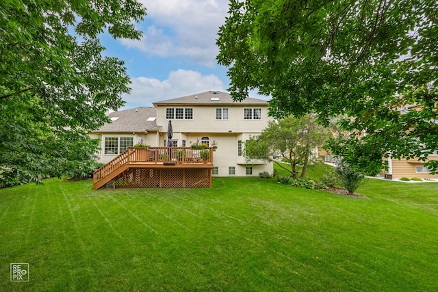 rear view of property featuring stairway, a yard, and a deck