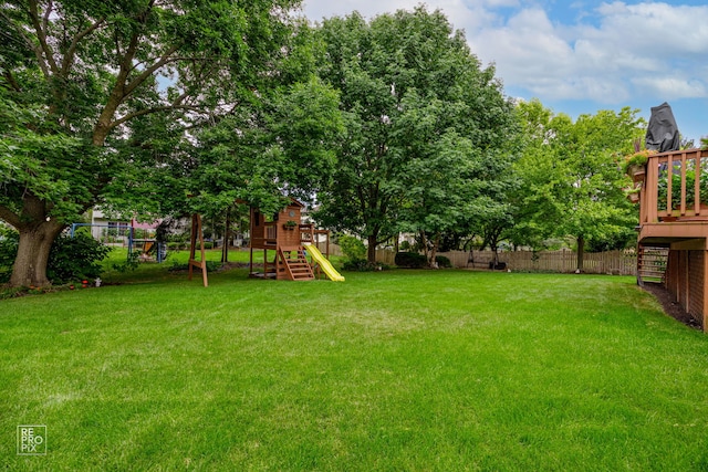 view of yard with a playground, stairs, a fenced backyard, and a wooden deck