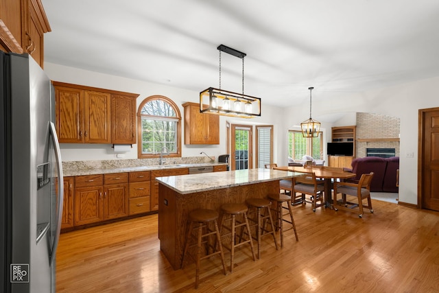 5324 Switch Grass Ln, Naperville, IL 60564 - kitchen featuring light wood finished floors, appliances with stainless steel finishes, brown cabinets, and a kitchen island
