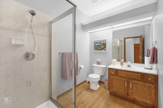 bathroom featuring toilet, a shower stall, wood finished floors, and vanity