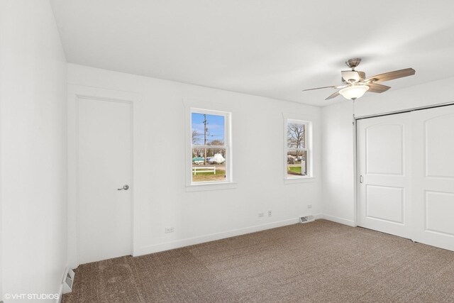 unfurnished bedroom featuring baseboards, a closet, visible vents, and carpet