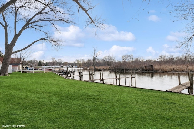 view of dock featuring a lawn and a water view