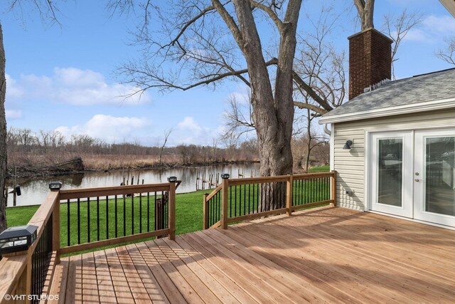 deck featuring a yard, french doors, and a water view