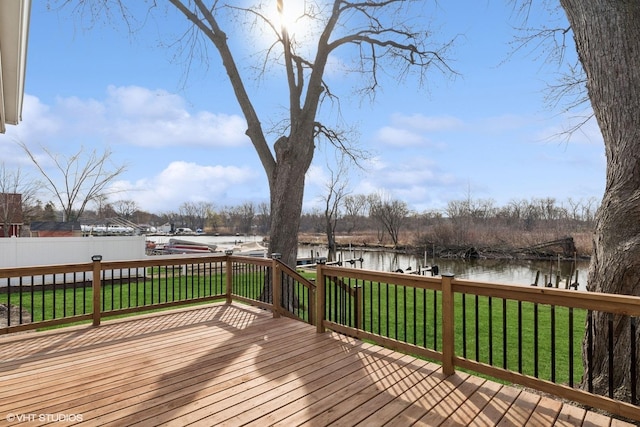 wooden deck with fence, a water view, a yard, and a dock