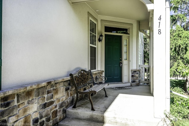418 Bay Tree Cir, Vernon Hills, IL 60061 - view of exterior entry with stucco siding, a porch, and stone siding