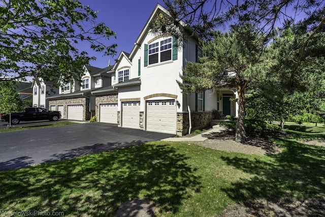 418 Bay Tree Cir, Vernon Hills, IL 60061 - view of front of home featuring an attached garage, driveway, stone siding, a front lawn, and stucco siding