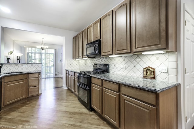 418 Bay Tree Cir, Vernon Hills, IL 60061 - kitchen with black appliances, light wood-type flooring, a sink, a chandelier, and decorative backsplash