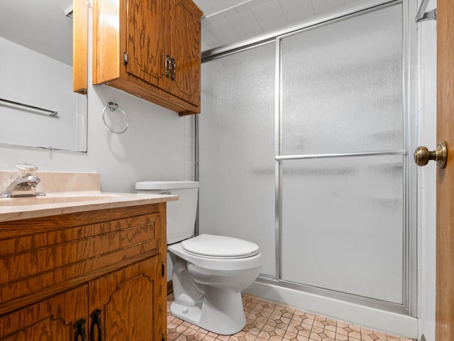 bathroom featuring a shower stall, vanity, and toilet