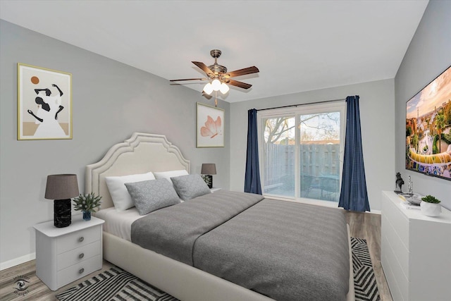 bedroom with ceiling fan, access to exterior, baseboards, and wood finished floors