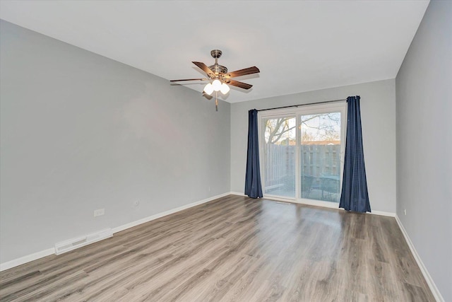 unfurnished room with visible vents, baseboards, a ceiling fan, and wood finished floors