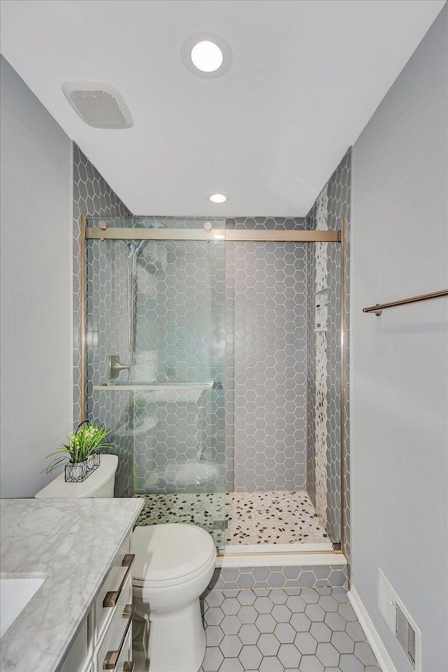 full bath with a shower stall, vanity, tile patterned flooring, visible vents, and toilet