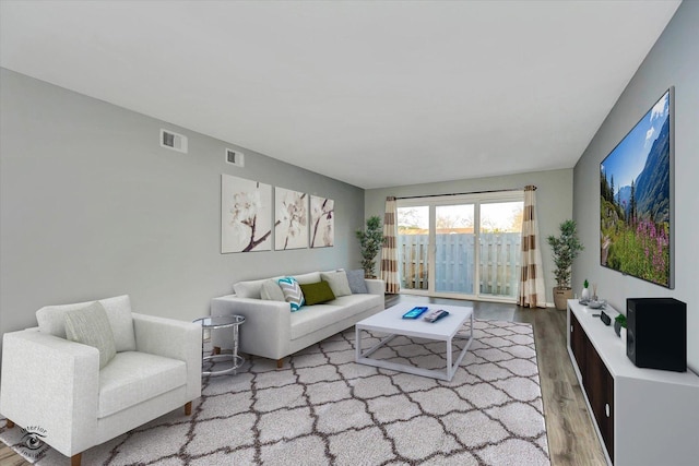 living area featuring visible vents and wood finished floors