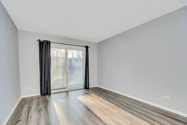 unfurnished room with baseboards and wood finished floors
