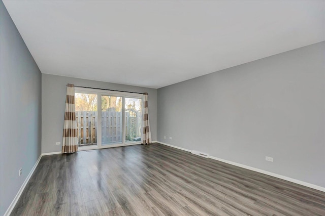 spare room with visible vents, baseboards, and wood finished floors
